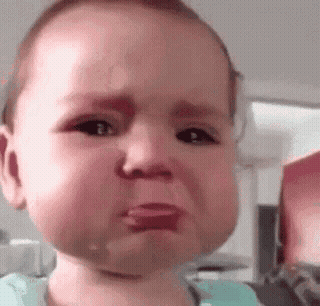 A little baby making a teary, apologetic face